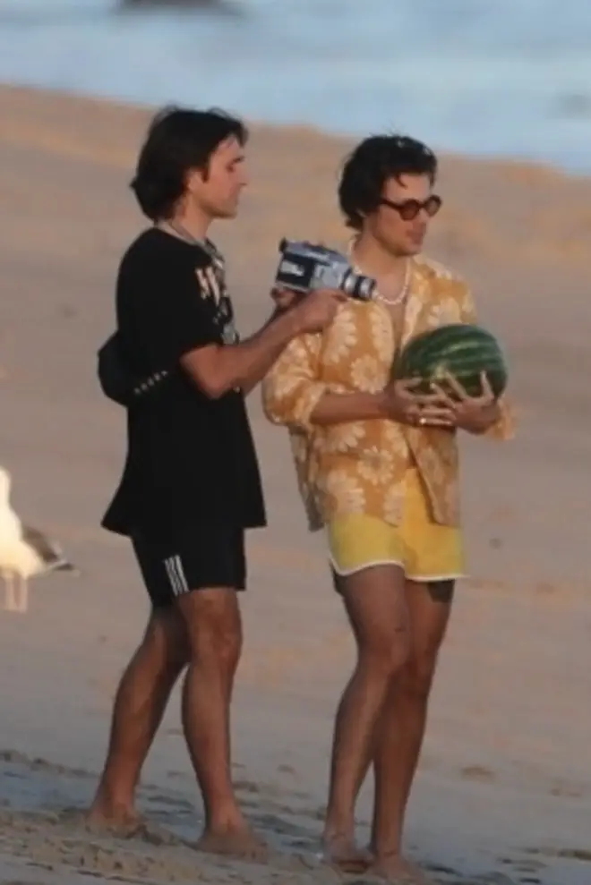 Harry Styles holds a watermelon on Malibu beach whilst shooting a music video