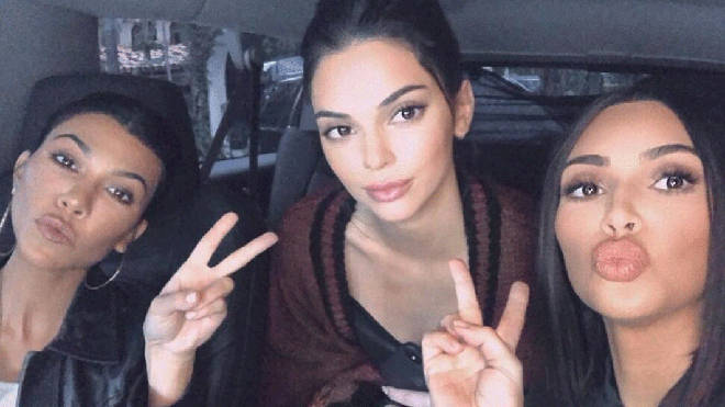 Kim and Kourtney Kardashian pose with sister Kendall Jenner