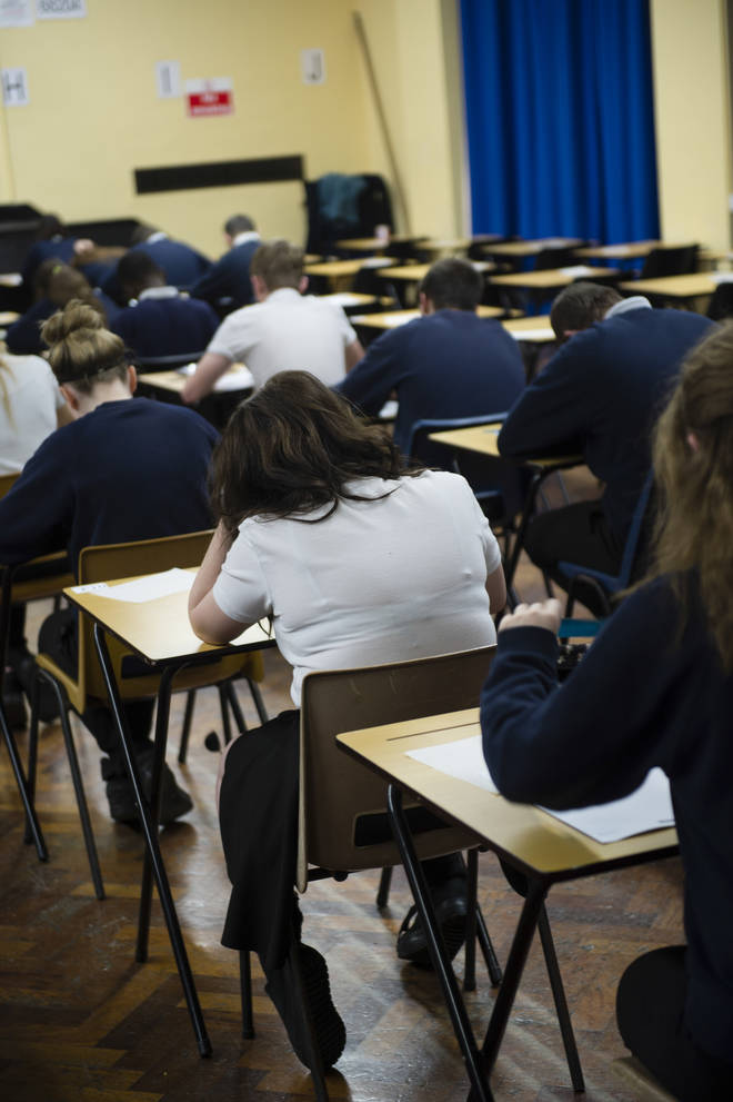 Welsh GCSE school pupils sitting exams in a school hall, Wales UK