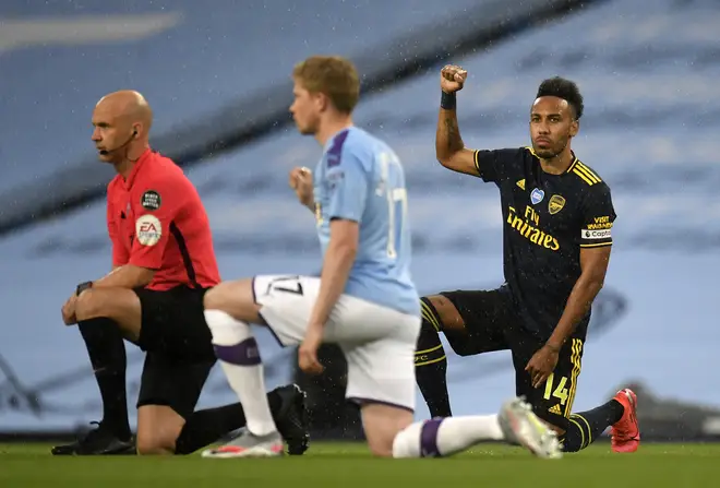 Premier League players and staff knelt before their football match started