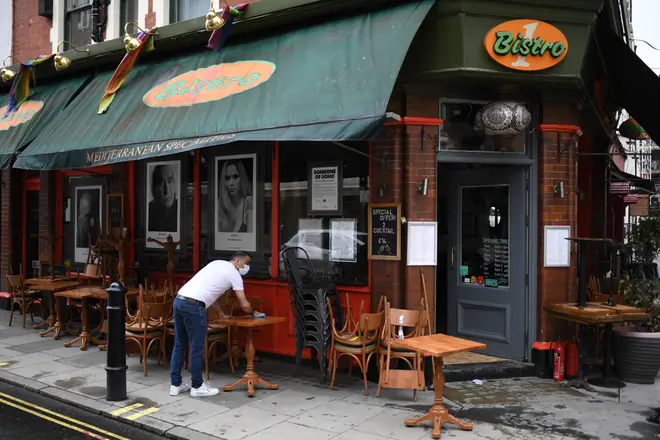 Pub worker cleans tables ahead of the business reopening