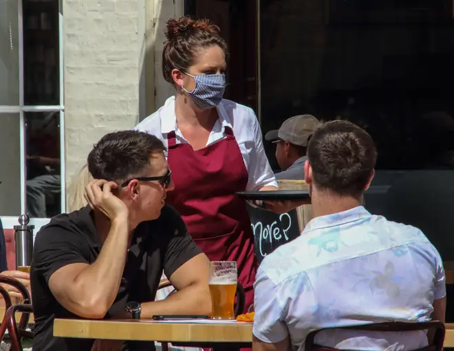 A waitress wearing a face mask as a preventive measure...