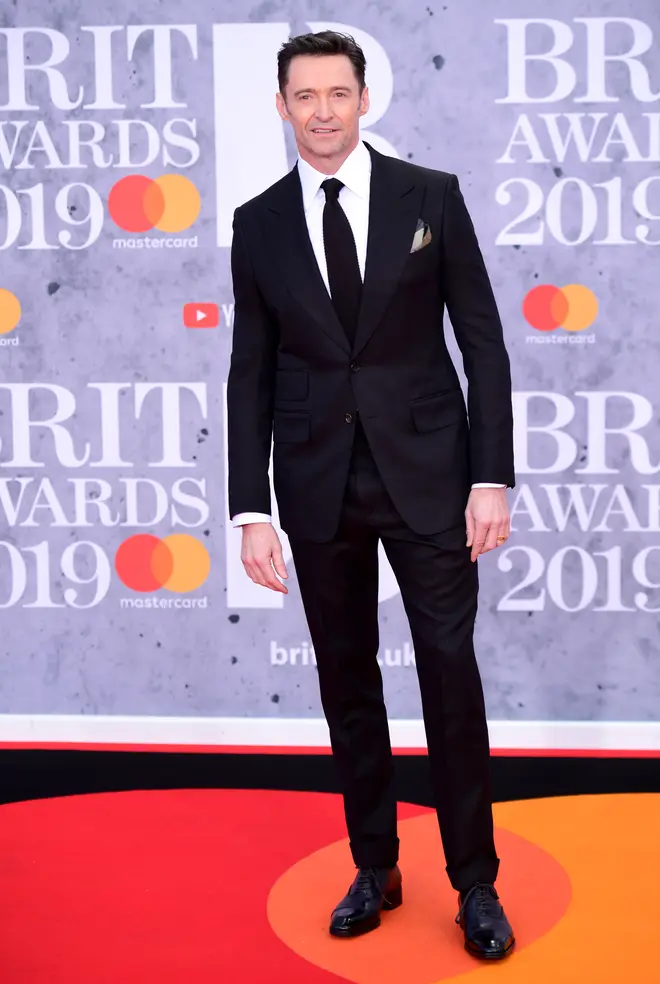 Hugh Jackman walks the 2019 BRITs red carpet in a tailored suit