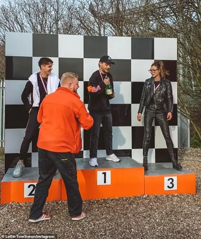 Louis Tomlinson on the winner's podium after go-kart racing