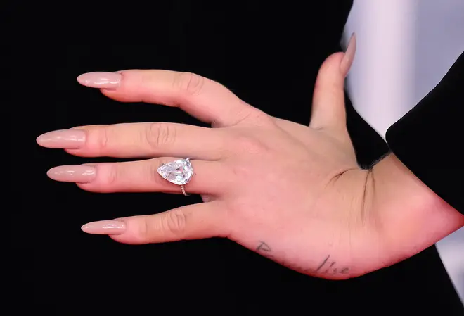 The enagement ring is pear-shaped diamond on a silver band