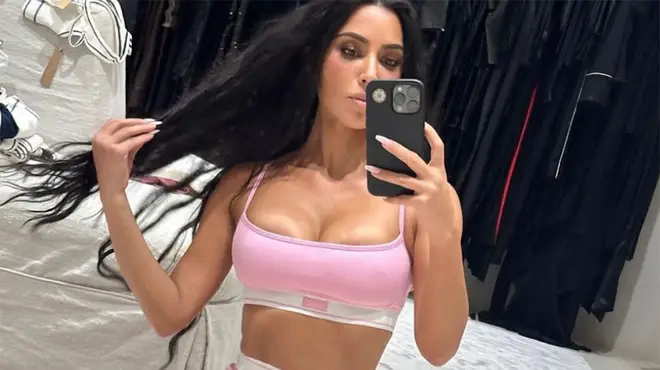 Kim Kardashian posing in pink Skims underwear for mirror selfie