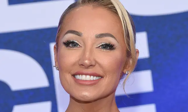 Mary Fitzgerald smiling on the red carpet with her hair pulled back in a bun