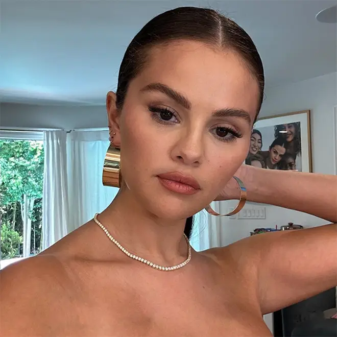 Selena Gomez wearing huge gold loops and diamond necklace while taking a selfie