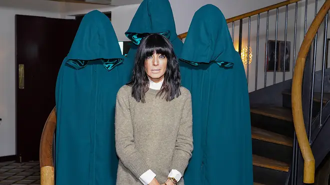 Claudia Winkleman standing in front of three traitors