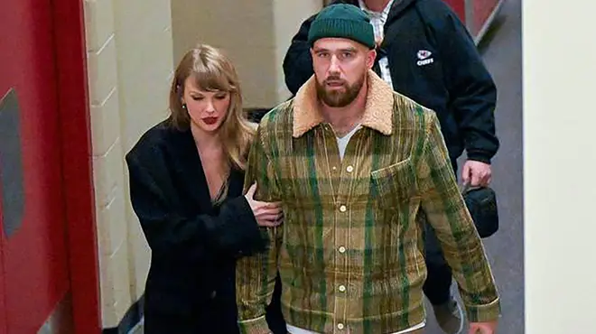 Taylor Swift and Travis Kelce holding hands backstage