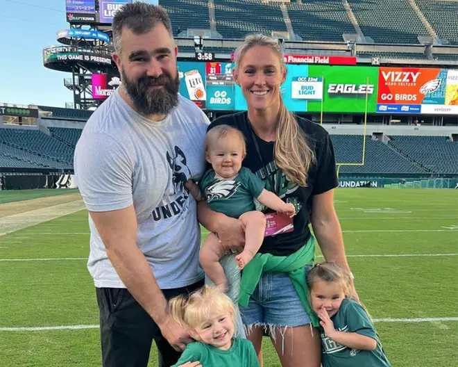 Jason Kelce with his wife Kylie and their three daughters on a football field