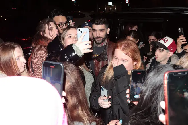 Zayn taking photos with a group of fans